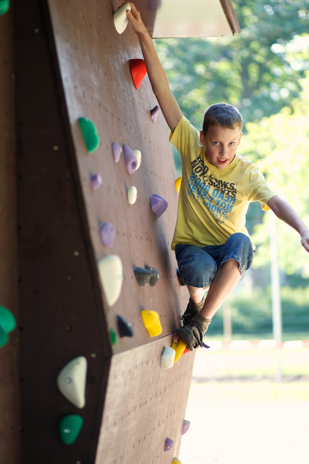 Schülerinnen und Schüler klettern an der Boulderwand auf dem Schulgelände
